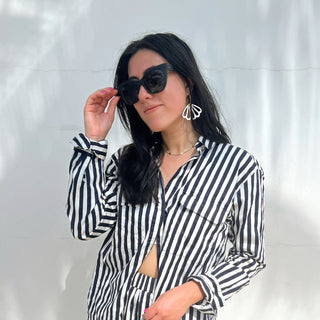 Model wearing Black Bella Sunglasses with our White Shelly Hoop earrings, outside